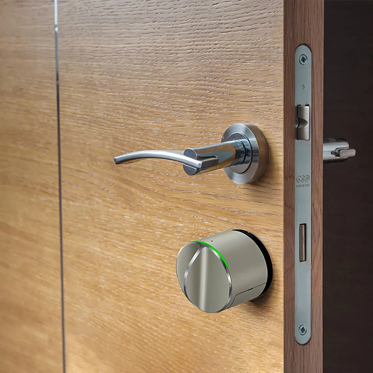 Ηλεκτρονικό κλείδωμα τοποθετημένο σε ξύλινη πόρτα, δίπλα σε μεταλλικό χερούλι, με μοντέρνο και κομψό σχεδιασμό.