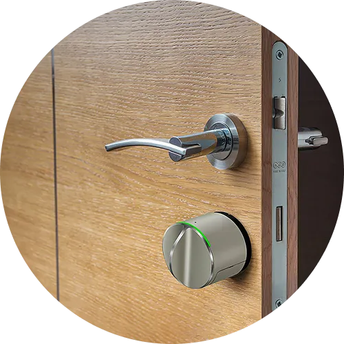 Ηλεκτρονικό κλείδωμα τοποθετημένο σε ξύλινη πόρτα, δίπλα σε μεταλλικό χερούλι, με μοντέρνο και κομψό σχεδιασμό.